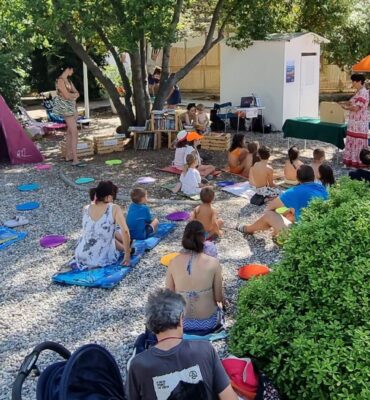 Otroci poslušajo pravljico na plaži v Sesljanu.